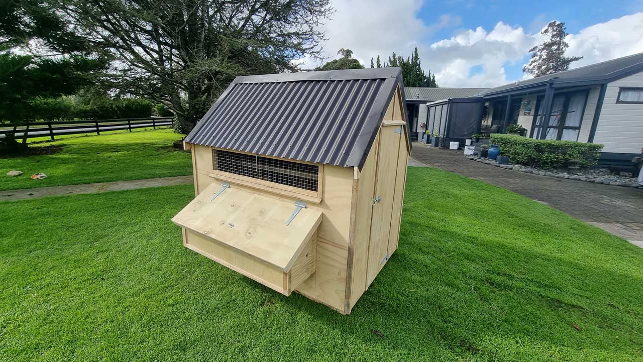 Medium sized chicken coop in a yard.